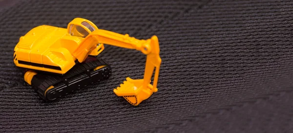 Gelber Bagger Auf Unscharfem Schwarzem Hintergrund Baumaschinen Spielzeugauto Für Kinder — Stockfoto