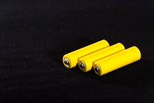 Tre Gula Batterier Närbild Mörk Svart Suddig Bakgrund Elektricitet Batterikraft — Stockfoto