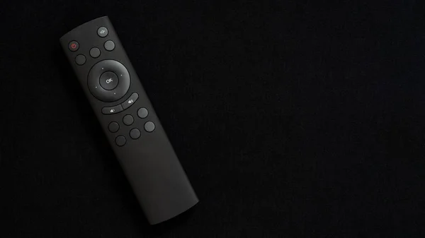 黒のエンボス加工の背景に黒のテレビリモコン テレビの制御と番組の切り替え スマートハウス 楽しい時間を過ごしてください テレビ番組や映画を観る ロイヤリティフリーのストック写真