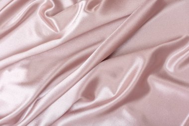 Pembe saten kumaş. Tekstil arka planı. Pudralı bir renk. Kumaş dalgaları ve kıvrımları.