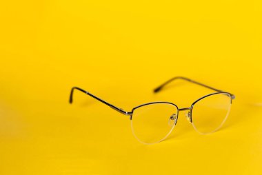 Beyaz arka planda ince metal yarı çember çerçeveli şık kadın gözlükleri. Vizyon düzeltme kavramı.