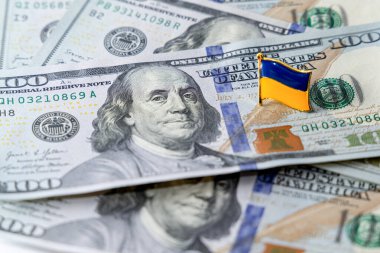 Yüz dolarlık banknotlar masaya saçıldı. Ukrayna 'nın ulusal bayrağı dolarların üzerinde. Ukrayna 'da mali siyasi skandal.