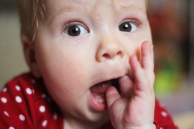 Ağız içinde el ile sürpriz küçük çocuk