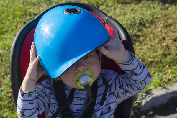 Un bambino su una sedia a rotelle non vuole stare al casco — Foto Stock