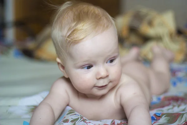 Bebê bonito deitado na cama, retrato, foco suave Fotos De Bancos De Imagens