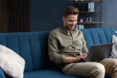 Evde dizüstü bilgisayarla çalışan genç bir serbest yazar. Mesajlaşmalar, internette gezinmeler. Çevrimiçi eğitim, online eğitim, uzaktan çalışma. Evde çalışan gençler. İş konsepti