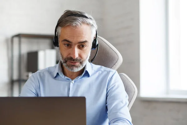 Online education, remote working, home education. Portrait of grey-haired senior handsome man teaching online. Online meeting, video call, video conference, courses online