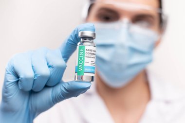 SARS - CoV2 aşı konsepti. COVID-19 aşısı dozunu kapat. Laboratuvarda bir doktor ya da hemşire bir aşı şişesi bulundurur. Salgın bağışıklığı.