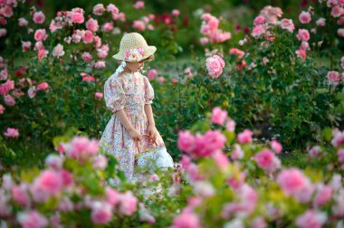 Bir sepet ve gül çiçeği p ile bir şapka ile küçük mutlu kız