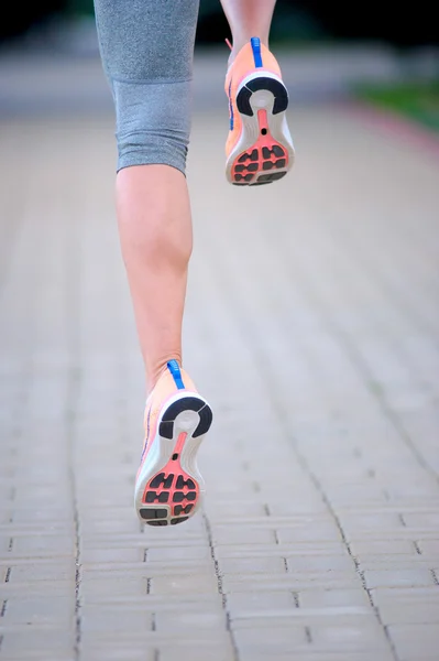 Pés de um atleta que corre em um treinamento de caminho de parque de fitnes — Fotografia de Stock