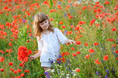 Beyaz elbiseli haşhaş çiçek fiel oynayan sevimli küçük kız