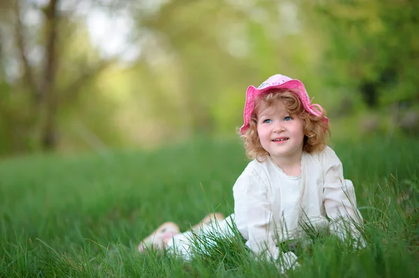 Gra で遊んでスタイリッシュな白いドレスを着て子供少女の笑みを浮かべてください。 — ストック写真