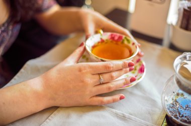 Elinde çay tutan bir kadın.