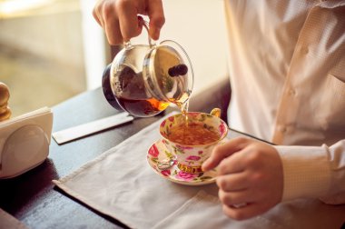 adam çay fincan içine dökülen.