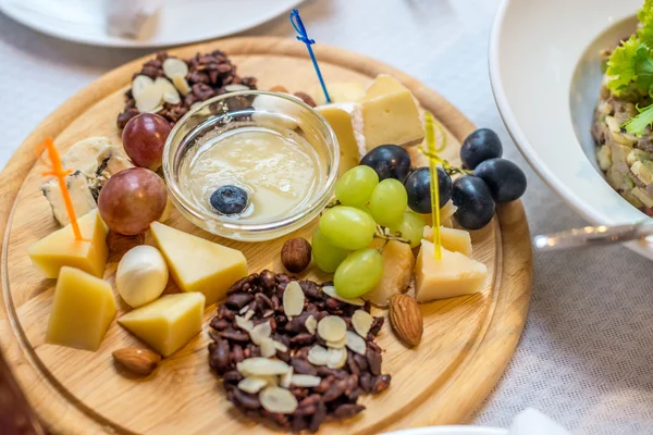 Cheese plate, grapes, nuts — Stock Photo, Image