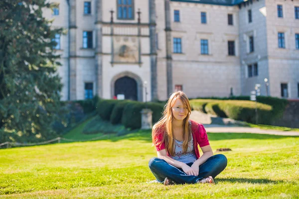 Mädchen sitzt auf dem Hintergrund des Schlosses — Stockfoto