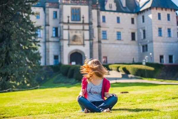 Girl sits on a background of the castle — Stock Photo, Image