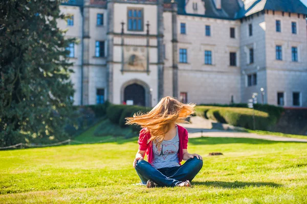 Flickan sitter på en bakgrund av slottet — Stockfoto