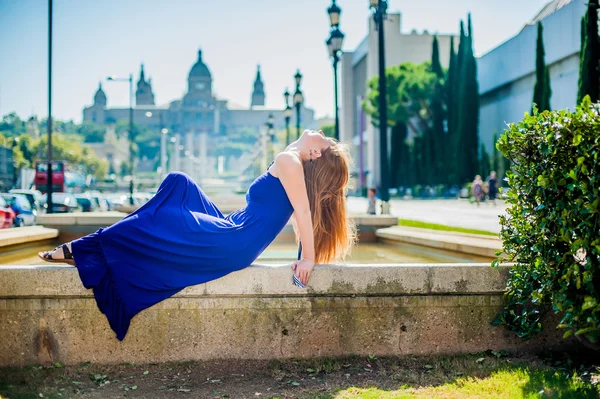 Mädchen sitzt auf dem Rand des Brunnens — Stockfoto