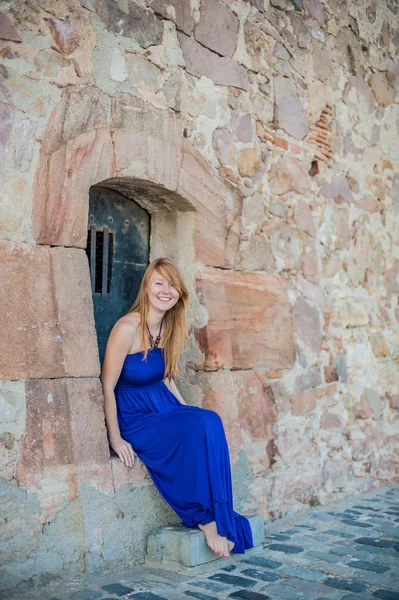 Girl sits in an old wall — Stock Photo, Image