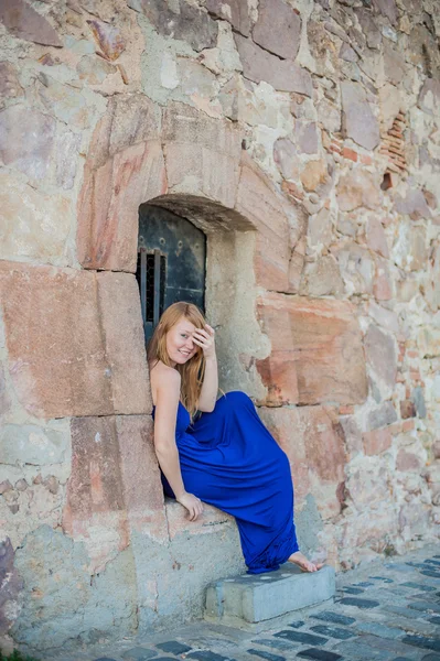 Girl sits in an old wall — Stock Photo, Image