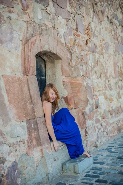 Girl sits in an old wall — Stock Photo, Image