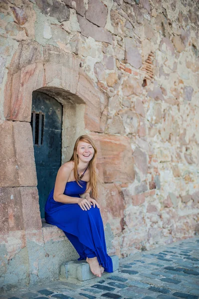 Girl sits in an old wall — Stock Photo, Image