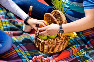 Erkek ve kadın için bir elma bir piknikte yakaladı