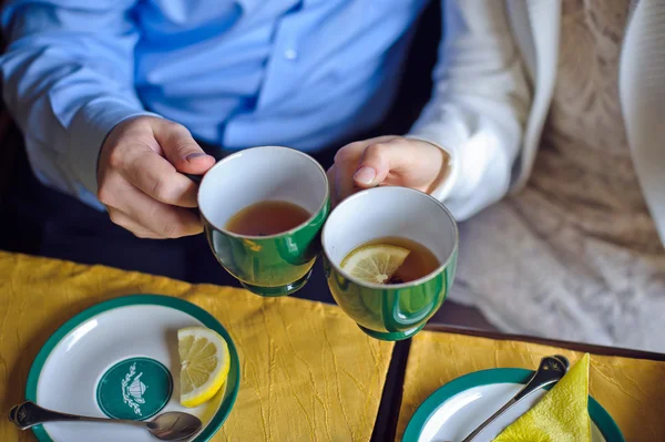 Pria dan wanita minum teh hitam dengan lemon cangkir — Stok Foto