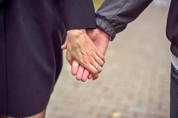 Hombre y mujer tomados de la mano — Foto de Stock