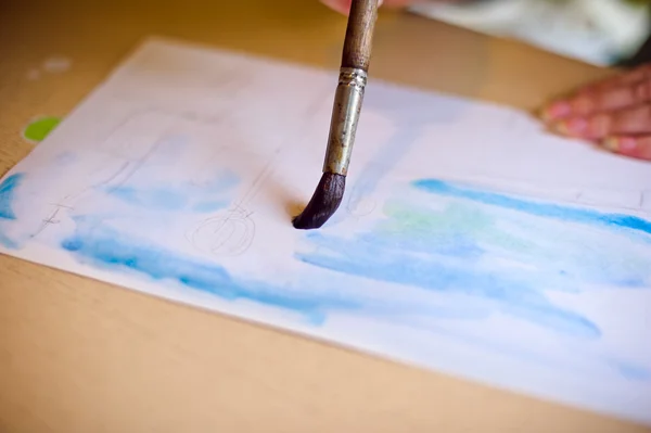 Draws the brush on the paper blue — Stock Photo, Image