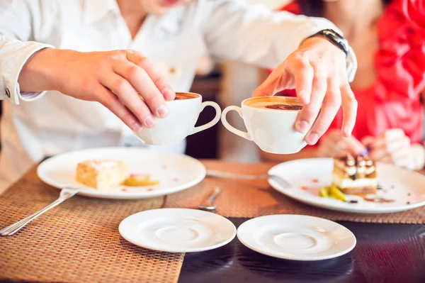 Чоловік і жінка тримають чашку кави, з серцями в кафе — стокове фото