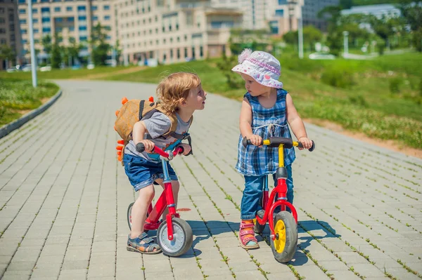 Τα νήπια αγόρι και κορίτσι φιλιά με ποδήλατα ισορροπίας στο πάρκο καλοκαίρι — Φωτογραφία Αρχείου