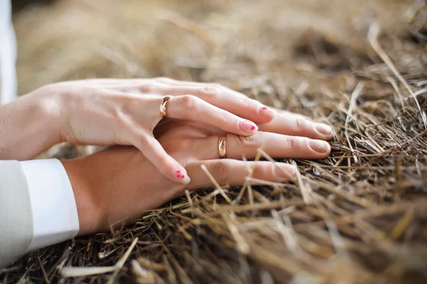 Männliche und weibliche Hand auf Stroh — Stockfoto