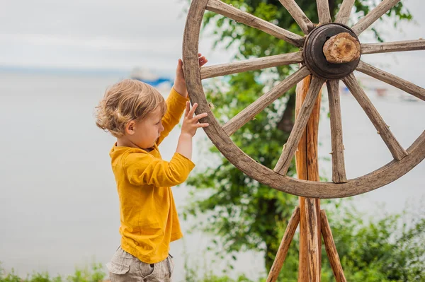 Boy spinning wooden wheel — Stock Photo, Image