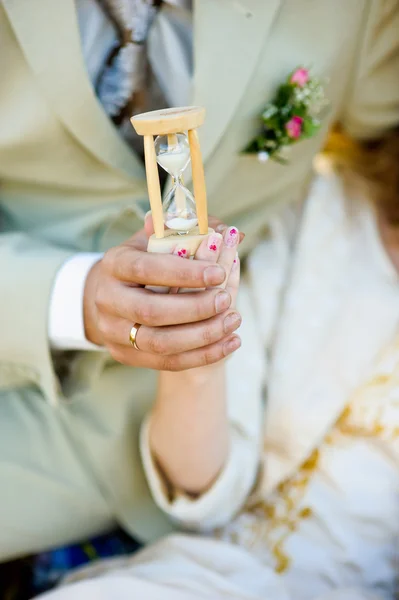 Hourglass in the hands of man and woman — Stock Photo, Image