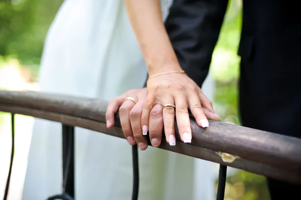 Les mains de la mariée et du marié sur la rampe — Photo