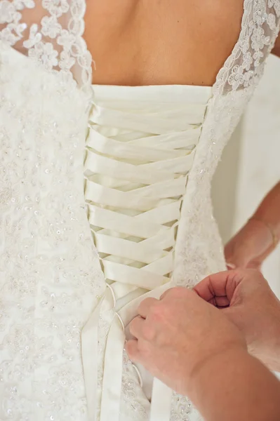 Bride putting on her wedding dress — Stock Photo, Image