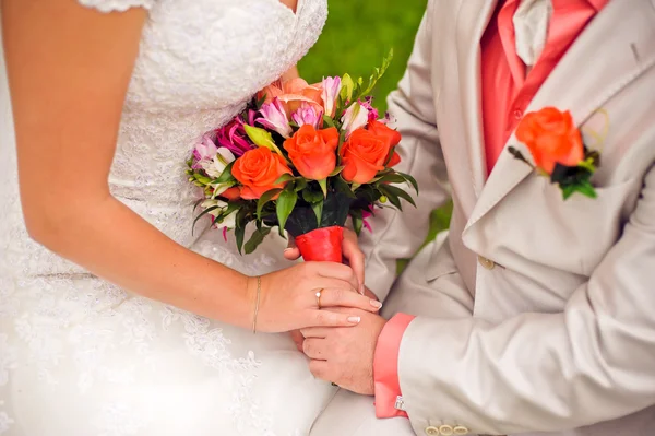 Bride and groom are holding bridal bouquet — Stock Photo, Image