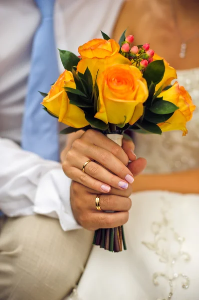 Nevěsta a ženich se drží svatební kytice — Stock fotografie