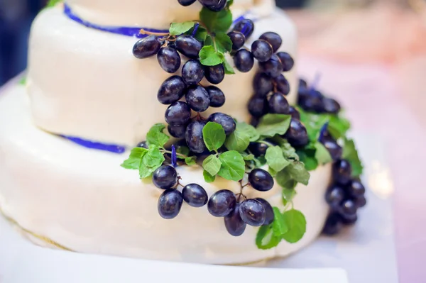 Biały tort z winogron i niebieskie wstążki — Zdjęcie stockowe