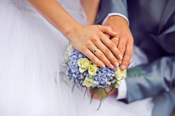 Les mains du marié et de la mariée avec des alliances — Photo