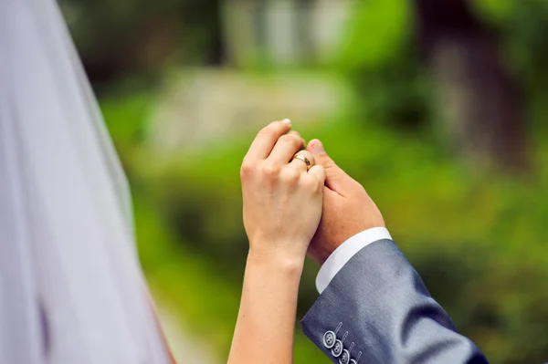 Handen van de bruidegom en de bruid met bruiloft ringen — Stockfoto