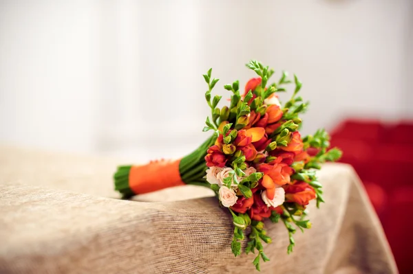 Orangefarbener Brautstrauß auf beiger Tischdecke — Stockfoto