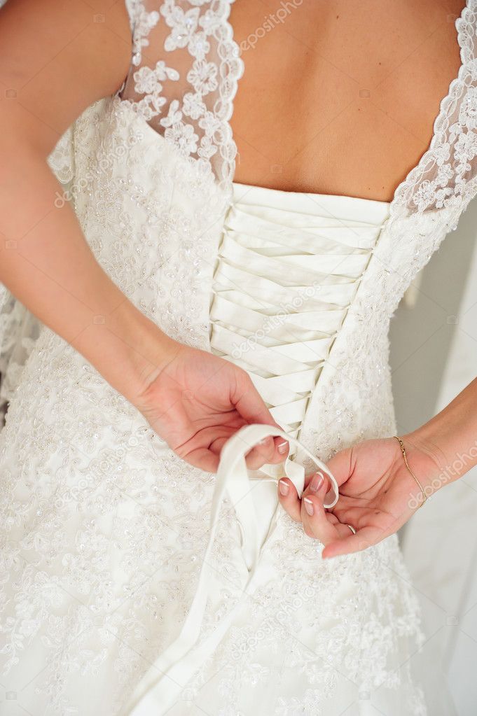 Bride putting on her wedding dress