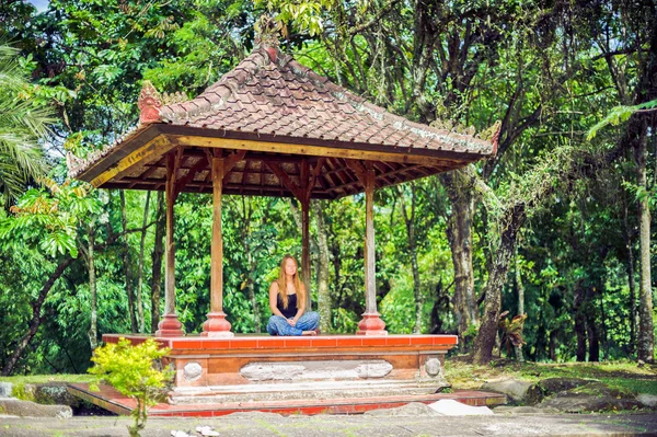 Menina medita no gazebo no jardim Bali — Fotografia de Stock