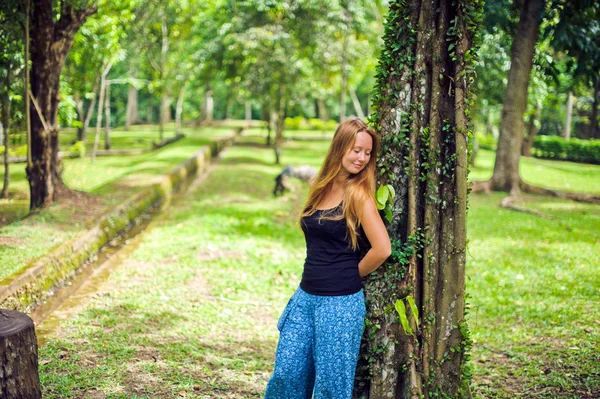 Flicka i en tropisk trädgård — Stockfoto