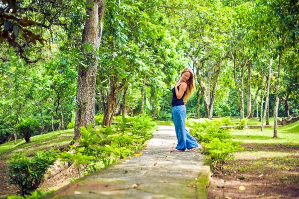The girl walks in a tropical garden — Stock Photo, Image