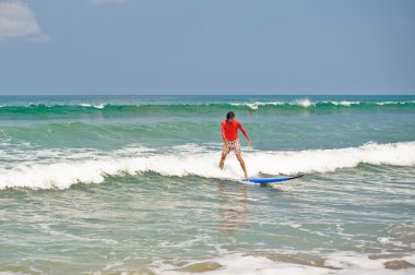 Wetsuit plajda sörf tahtası ile adam