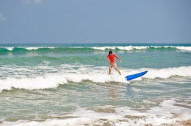 Wetsuit plajda sörf tahtası ile adam
